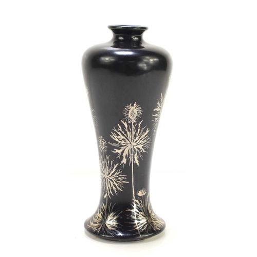 35 - A small Ruskin Pottery vase, having a matte black body and decorated with silver floral sprays, 13.5... 