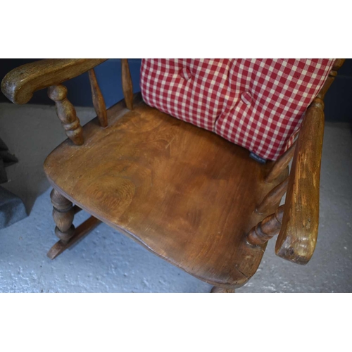 491 - A 19th century American elm spindle back rocking armchair with slab seat and turned legs with two cu... 