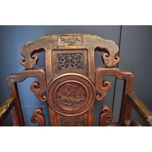 494 - A Chinese carved temple chair, the shaped back having decoratively pierced panels and a central roun... 