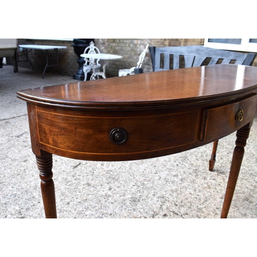 503 - A Regency mahogany side table of demi-lune form with two drawers flanked by dummy drawers raised on ... 