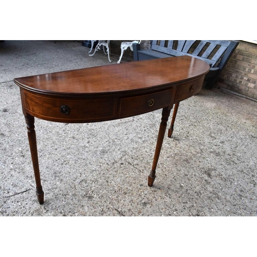 503 - A Regency mahogany side table of demi-lune form with two drawers flanked by dummy drawers raised on ... 