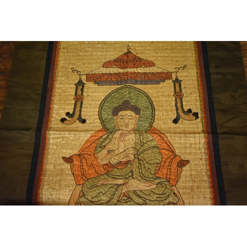 248 - A late 19th century Buddha beneath a canopy, floss silk with wrapped thread outline, silk lozenge pa... 