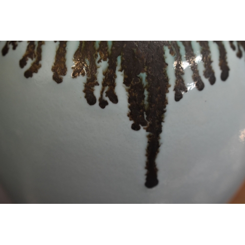 100 - Bridget Drakeford (b.1946): A maroon glazed jug with vertical striped pattern and knot form handle t... 