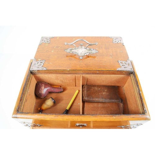 23 - An Edwardian oak smokers compendium, with sliding top and drawer, with compartments throughout, and ... 