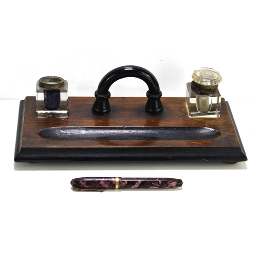 28 - A vintage Conway Stewart 84 fountain pen with a 14ct gold nib together with an oak inkstand with two... 