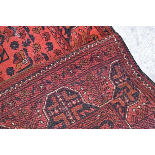 255 - A very long wool runner, the red ground with geometric stylised motifs 81 by 500cm.