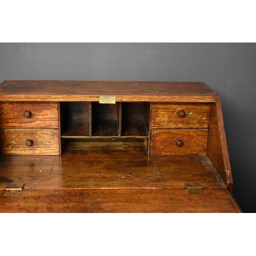 50 - An old Etonian Victorian elm bureau bearing residual student graffiti and key with Eton College tag,... 