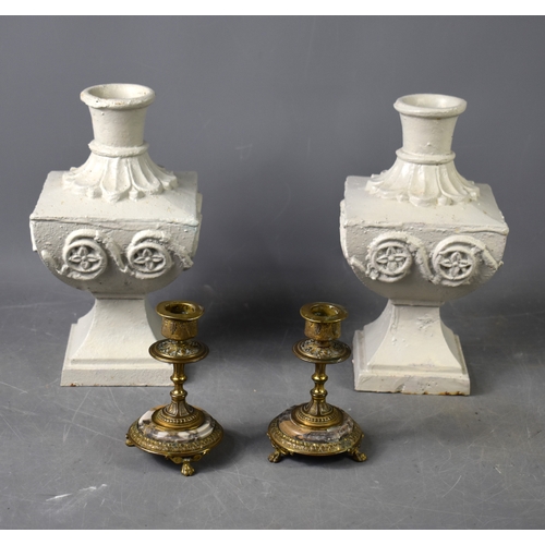 235 - A pair of painted cast iron candle sticks of large form together with a pair of brass candlesticks.