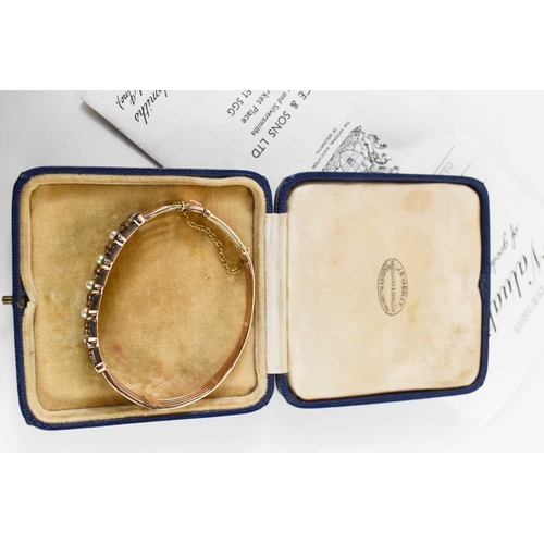 10 - A 19th century gold (tested as 14ct), diamond, pearl and coloured stone set bangle, set in five line... 