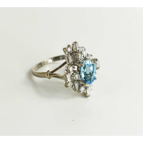 11 - An 18ct white gold, diamond and topaz dress ring, the central oval cut Topaz of approximately 6 by 8... 