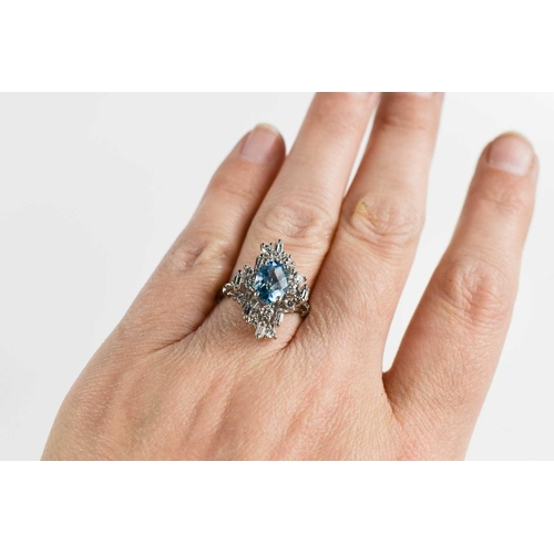 11 - An 18ct white gold, diamond and topaz dress ring, the central oval cut Topaz of approximately 6 by 8... 