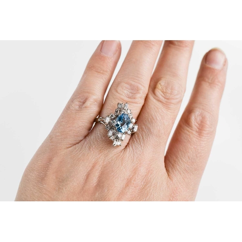 11 - An 18ct white gold, diamond and topaz dress ring, the central oval cut Topaz of approximately 6 by 8... 