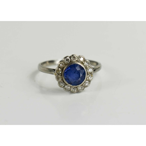 141 - An Art Deco sapphire and diamond flowerhead ring, with central deep cornflower blue sapphire surroun... 