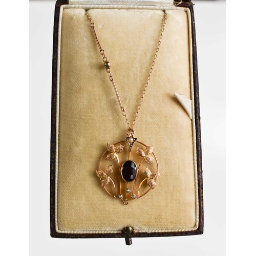 2 - An Art Nouveau period rose gold, garnet and seed pearl set pendant necklace, the roundel pendant com... 