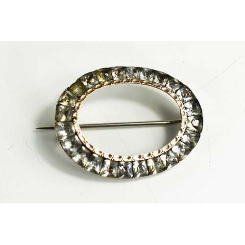 218 - A Georgian paste buckle, of oval form set with twenty four cut white paste stones, with rose gold bo... 