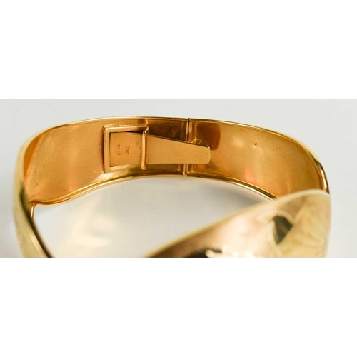 3 - An 18ct gold bangle, engraved with foliage and shaped in the form of leafy fronds, 30g.