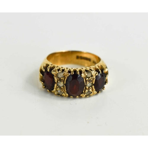 31 - A vintage 9ct gold garnet dress ring the three oval garnets interspersed with two rows of three whit... 