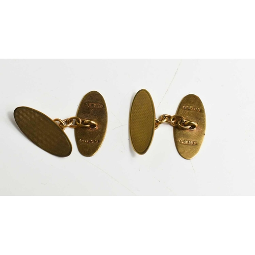 45 - A pair of 9ct gold cufflinks of oval form, with machine engraved decoration, 4.77g.