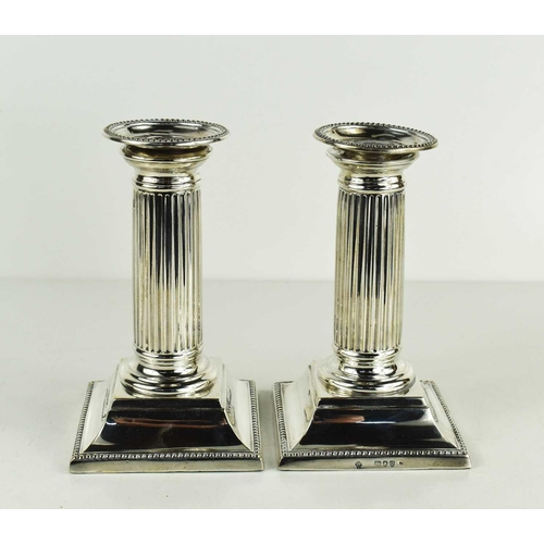 457 - A pair of silver column form candlesticks, hallamarked for London, 13.5cm.