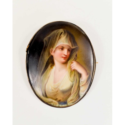 458 - A 19th century oval porcelain brooch / pendant, painted with a woman wearing a white veil, in a gilt... 