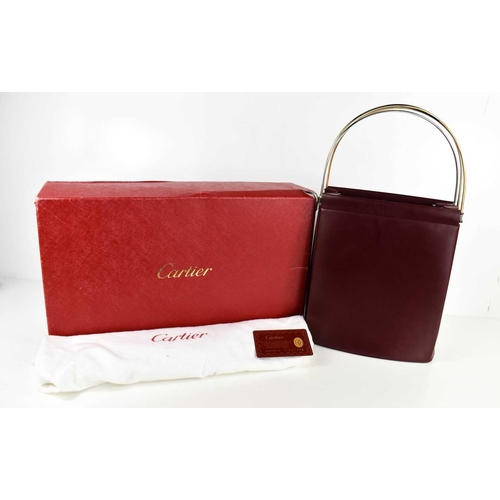 479 - A Cartier Handbag of concertina form in burgundy leather with three arched tri-gold coloured metal h... 