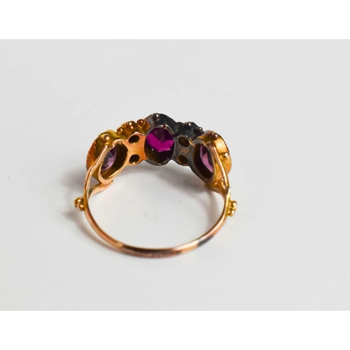 48 - A 19th century gold (unmarked) and paste ring, the three oval cut pink stones of differing shades, i... 