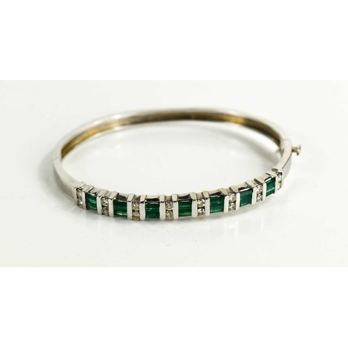 6 - A 14ct white gold, diamond and emerald demi parure, consisting a bangle set with seven baguette cut ... 