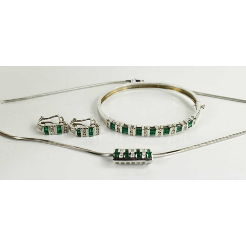 6 - A 14ct white gold, diamond and emerald demi parure, consisting a bangle set with seven baguette cut ... 