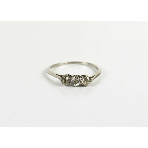 61 - A white gold (testing as) and diamond three stone ring, size T½, 2.75g.