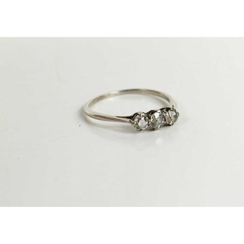 61 - A white gold (testing as) and diamond three stone ring, size T½, 2.75g.