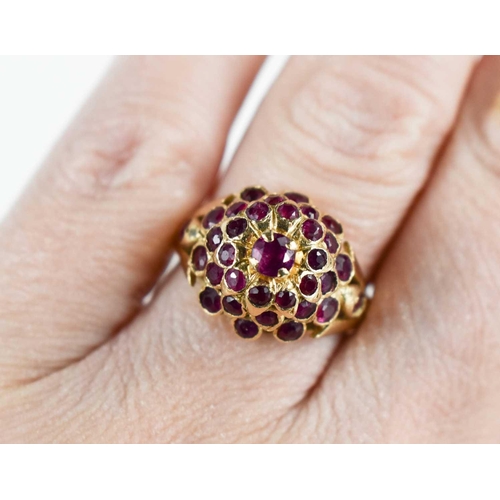 85 - A 14ct gold and pink sapphire cluster / flower head ring, of raised form with central brilliant cut ... 