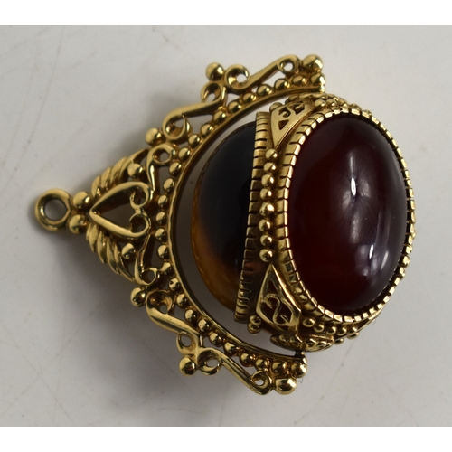 46a - A 9ct gold swivel fob, set with three large cabochons, of tiger's eye, black onyx and agate, within ... 