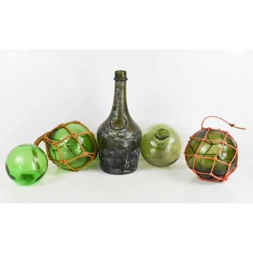 155 - Four antique green glass fishermans balls, and an excavated Benedictine bottle 28cm high.