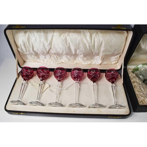 175 - A set of cranberry cut glass port glasses, in the original presentation case, together with a part s... 