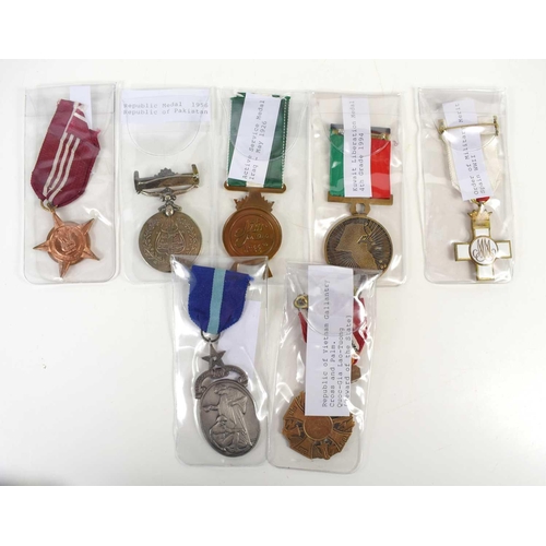 18 - A group of military medals to include a WWII Spain Order of Military Merit medal, Republic of Vietna... 