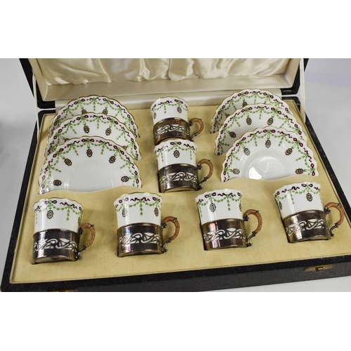 225 - A cased set of Royal Worcester coffee cans and saucers, puce mark 1910, painted with garlands and ri... 