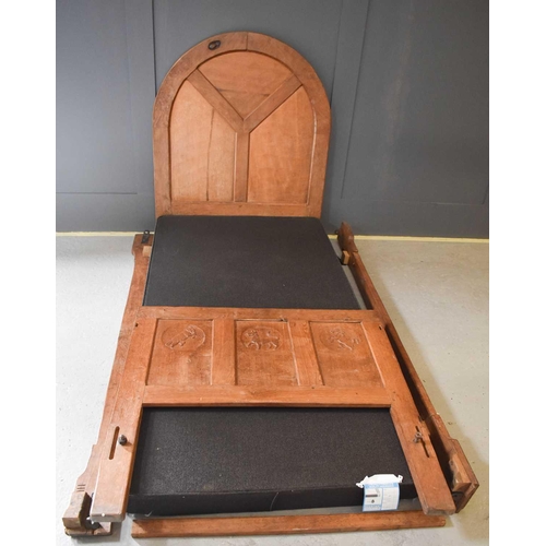 514 - A Robert Mouseman Thompson early 1930s single bed, the three panel headboard carved with roundels, e... 