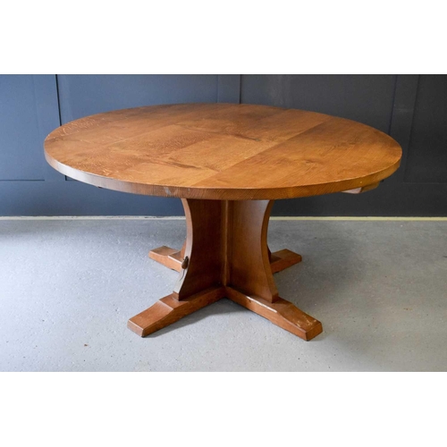 518 - A Robert Thompson Mouseman oak dining table of circular form, the adzed top riased on a cruciform ba... 