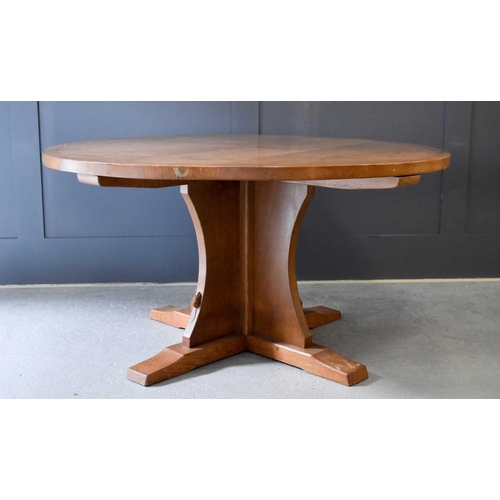 518 - A Robert Thompson Mouseman oak dining table of circular form, the adzed top riased on a cruciform ba... 