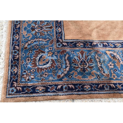 519 - An Indian wool carpet, in mustard brown with blue border, 276 by 363cm.