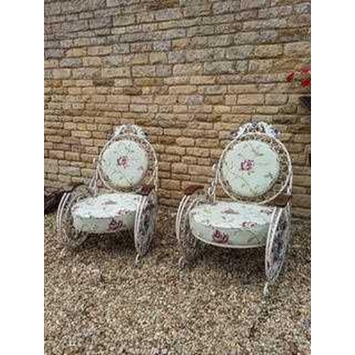 521 - A pair of fin-de-siecle cast iron garden chairs, with wrought iron roses, the frame painted cream wi... 