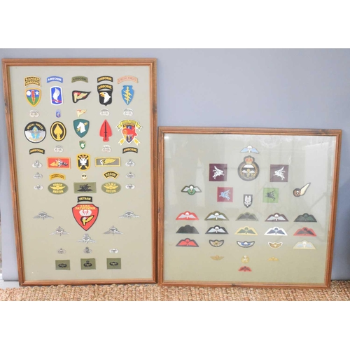 56 - Two framed panels of military cloth patches and metal badges to include US special forces and airbor... 