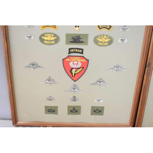 56 - Two framed panels of military cloth patches and metal badges to include US special forces and airbor... 