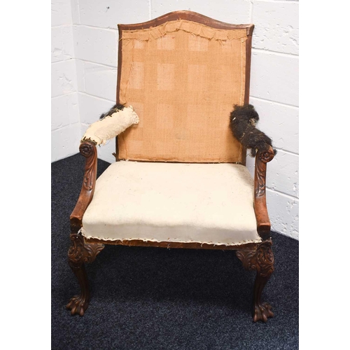 568 - An 18th century and later walnut framed armchair, lacking upholstery, the wide carved arms adjoining... 