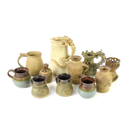 64 - John Brooke Steel: A group of studio pottery to include a mystical beast handled jug, mugs, jugs and... 