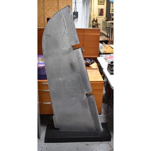 160 - A vintage aeroplane aileron mounted on a black granite base.