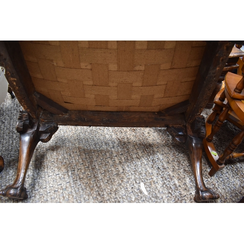 568 - An 18th century and later walnut framed armchair, lacking upholstery, the wide carved arms adjoining... 