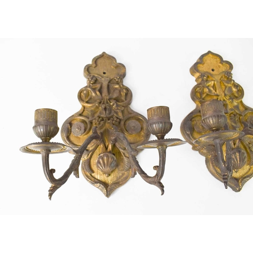 104 - A pair of gilt metal French 19th century wall sconces, the cast embossed backplates emanating twin b... 
