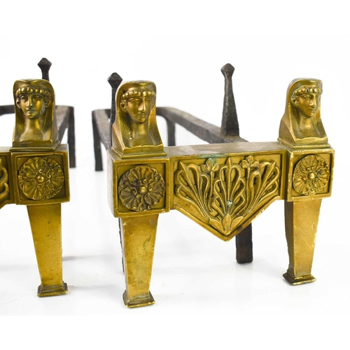 105 - A pair of Egyptian revival brass and iron andirons, each having two face masks above rosettes, 18cm ... 