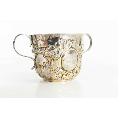 134 - A Queen Anne period twin handled silver cup, bearing the initials GR, WH and dated 1717, embossed wi... 